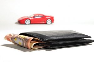 Czerwony samochód i portfel z pieniędzmi