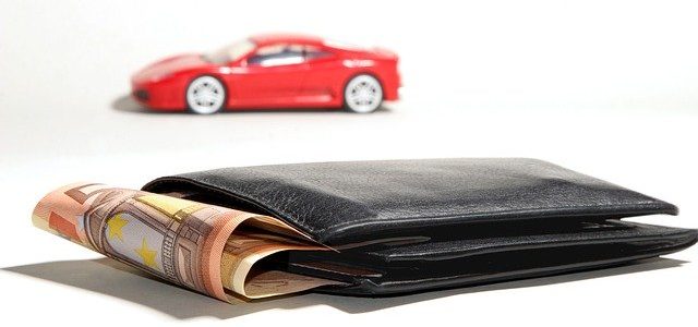 Czerwony samochód i portfel z pieniędzmi
